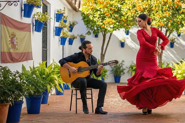 Tancerka flamenco w czerwonej sukni i gitarzysta na tradycyjnym hiszpańskim patio – zapowiedź wiosennych kursów języka hiszpańskiego online w Alma Española.