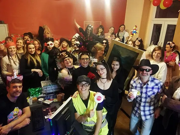 Grupa uśmiechniętych kursantów i lektorów szkoły Alma Española w przebraniach podczas imprezy integracyjnej – przykład wyjątkowej atmosfery i budowania społeczności.